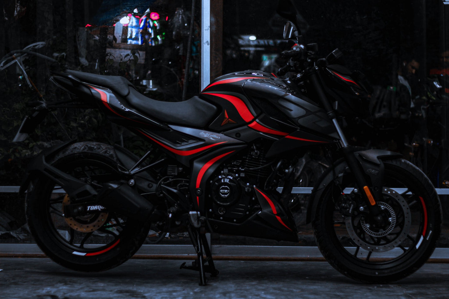 Side view of a motorcycle with an N160 Wave Decal Kit, featuring striking red and black wave patterns on the body.