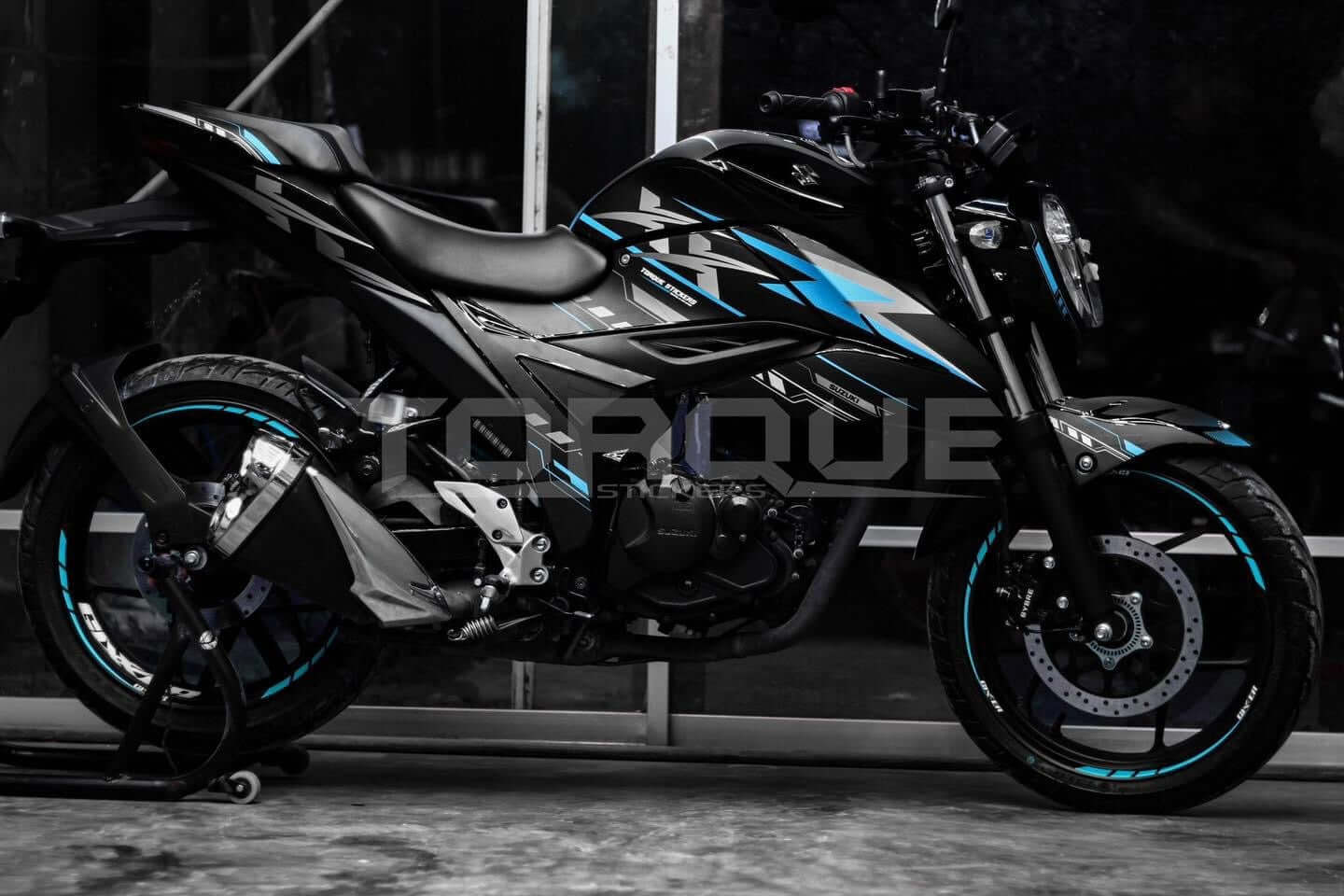 Side view of a black motorcycle featuring the Gixxer FI XX Decal Set with blue and gray accents on display.