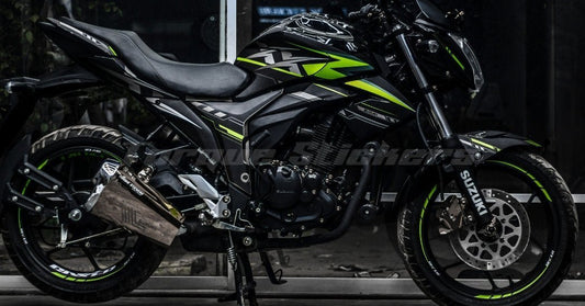 GIXXER MONOTONE XX DECAL SET showcasing sleek black and green design on a motorcycle parked indoors.