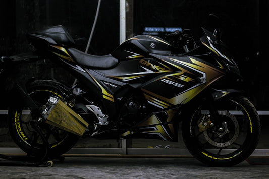 A Gixxer SF motorcycle featuring a sporty decal design with black and gold accents, displayed on a product page.